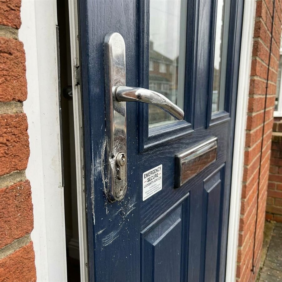 Damaged front door lock and scratched cylinder before emergency locksmith repair